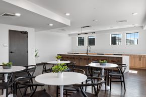 Madison apartment for rent - a room with white tables and chairs and a kitchen counter in the background